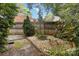 Serene backyard with a small rock garden and stone bench, nestled among mature trees and a wood privacy fence at 6921 Thermal Rd, Charlotte, NC 28211