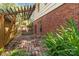 Charming brick patio next to a brick home featuring a pergola, green foliage, and a fenced yard at 6921 Thermal Rd, Charlotte, NC 28211