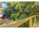 Tranquil view of a lush backyard with a wooden deck railing and diverse plantings, offering a serene outdoor escape at 6921 Thermal Rd, Charlotte, NC 28211