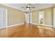 A bedroom with hardwood floors, tan walls, white trim, a ceiling fan, and two closets at 6921 Thermal Rd, Charlotte, NC 28211