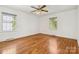 Bright bedroom with hardwood floors, ceiling fan, and natural light from two windows at 6921 Thermal Rd, Charlotte, NC 28211