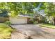 Spacious driveway leading to a two-car garage, complemented by lush landscaping and a brick pathway to the entrance at 6921 Thermal Rd, Charlotte, NC 28211
