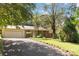 Traditional home with a well-manicured lawn, mature trees, and long driveway leading to an attached garage at 6921 Thermal Rd, Charlotte, NC 28211
