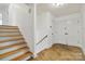 A foyer with stone flooring, wood stairs, white walls, and a coat closet at 6921 Thermal Rd, Charlotte, NC 28211