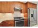A kitchen with wooden cabinets, granite countertops, tile backsplash, a gas range, and stainless steel appliances at 6921 Thermal Rd, Charlotte, NC 28211