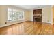 Inviting living room with hardwood floors, a brick fireplace, and large windows providing ample natural light at 6921 Thermal Rd, Charlotte, NC 28211