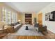 Cozy living room features a brick fireplace, hardwood floors, and large windows at 6921 Thermal Rd, Charlotte, NC 28211