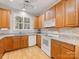 Well-lit kitchen featuring wood cabinets, white appliances, and granite countertops at 705 Torrey Pines Ln, Fort Mill, SC 29715