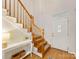 Elegant wooden staircase and front door illuminated by natural light, showcasing the home's interior at 705 Torrey Pines Ln, Fort Mill, SC 29715