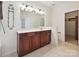 Bathroom boasts double vanity with wood cabinets and tile flooring at 7309 Rock Hampton Ct, Harrisburg, NC 28075