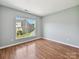 Bedroom with large window overlooking neighborhood and hardwood floors, a spacious and serene retreat at 7309 Rock Hampton Ct, Harrisburg, NC 28075