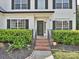 Inviting entryway with brick steps, a black front door, and manicured landscaping at 7309 Rock Hampton Ct, Harrisburg, NC 28075