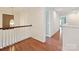 Bright hallway with hardwood floors and natural light, complemented by a white railing at 7309 Rock Hampton Ct, Harrisburg, NC 28075