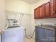 Bright laundry room with washer, dryer, storage, and shelving, perfect for efficient home organization at 7309 Rock Hampton Ct, Harrisburg, NC 28075