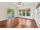 Open-plan room with hardwood floors, natural light, sliding glass doors to deck, and ceiling fan at 7309 Rock Hampton Ct, Harrisburg, NC 28075