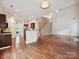Sunlit, open living space with hardwood floors offering a view of the kitchen and staircase at 7309 Rock Hampton Ct, Harrisburg, NC 28075