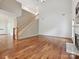 Spacious living room featuring hardwood floors, a staircase, and bright natural light at 7309 Rock Hampton Ct, Harrisburg, NC 28075