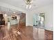 Bright open-concept layout with gleaming hardwood floors, sliding door access to a back patio and view of kitchen at 7309 Rock Hampton Ct, Harrisburg, NC 28075