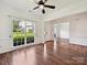 Bright living room featuring hardwood floors, a ceiling fan, and a large window at 7309 Rock Hampton Ct, Harrisburg, NC 28075