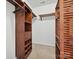 Organized walk-in closet featuring dark wood shelving and ample storage space, offering a neat and stylish storage solution at 7309 Rock Hampton Ct, Harrisburg, NC 28075