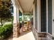 Relaxing front porch featuring classic rocking chairs and neutral stone columns at 741 Garrett Green Way # 64, Fort Mill, SC 29715