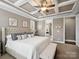 This main bedroom has a tufted headboard and ceiling fan and opens up into the main bathroom at 741 Garrett Green Way # 64, Fort Mill, SC 29715
