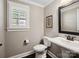 Elegant powder room featuring a pedestal sink, decorative mirror, and plantation shutters at 741 Garrett Green Way # 64, Fort Mill, SC 29715
