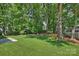 Expansive backyard with lush green lawn, a fire pit area, and mature trees at 811 Ashmeade Rd, Charlotte, NC 28211