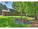 A picturesque backyard features a stone fire pit surrounded by Adirondack chairs, perfect for outdoor entertaining and relaxation at 811 Ashmeade Rd, Charlotte, NC 28211