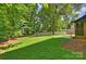 Lush backyard with fire pit area, bordered by mature trees and a white fence at 811 Ashmeade Rd, Charlotte, NC 28211