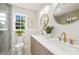 Bathroom with double sinks, modern fixtures, a large framed mirror, and natural light at 811 Ashmeade Rd, Charlotte, NC 28211