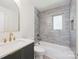 Modern bathroom featuring gray tiling, gold accents, and a tub-shower combination at 811 Ashmeade Rd, Charlotte, NC 28211