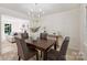 Stylish dining room with wainscoting, neutral furniture, contemporary lighting, and an inviting view into the living space at 811 Ashmeade Rd, Charlotte, NC 28211