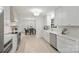 Bright kitchen with white cabinets, stainless steel appliances, modern fixtures, and an open view to the dining area at 811 Ashmeade Rd, Charlotte, NC 28211