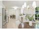 Open kitchen and dining area featuring stainless steel appliances, white cabinets, and modern light fixtures at 811 Ashmeade Rd, Charlotte, NC 28211