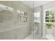 Modern shower area with a glass door and convenient shelving at 811 Ashmeade Rd, Charlotte, NC 28211
