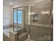 Modern bathroom featuring frameless glass shower and soaking tub at 8231 Annsborough Nw Dr, Concord, NC 28027