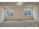 Spacious bedroom with plush carpeting, recessed lighting, and two large windows at 8231 Annsborough Nw Dr, Concord, NC 28027