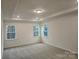 Spacious bedroom with tray ceiling, plush carpeting, recessed lighting, and large windows at 8231 Annsborough Nw Dr, Concord, NC 28027