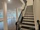 Inviting entryway with staircase and view to open floor plan featuring hardwood floors and white pillars at 8231 Annsborough Nw Dr, Concord, NC 28027