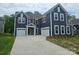 New construction home with blue siding, white trim, and a two-car garage plus a one car garage at 8231 Annsborough Nw Dr, Concord, NC 28027