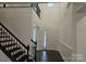View of the foyer with wood floors, wainscotting, stairs with black railings, and a hanging light at 8231 Annsborough Nw Dr, Concord, NC 28027
