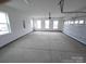 Spacious garage with roll-up door, multiple windows, and ample space for vehicles and storage at 8231 Annsborough Nw Dr, Concord, NC 28027