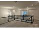 Second floor loft area with dark railing and neutral carpeting at 8231 Annsborough Nw Dr, Concord, NC 28027
