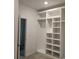 Spacious walk-in closet featuring a custom storage system with shelves, compartments, and carpet flooring at 8231 Annsborough Nw Dr, Concord, NC 28027