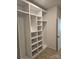 A custom walk-in closet featuring shelving and storage, alongside a carpeted floor and door at 8231 Annsborough Nw Dr, Concord, NC 28027