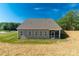 Exterior rear view of home with a screened-in porch, large windows, and freshly strawed yard at 10180 Lakeshore Dr, Lancaster, SC 29720