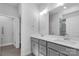 A bathroom featuring double sinks, a large mirror, gray cabinetry, and a tiled shower at 10180 Lakeshore Dr, Lancaster, SC 29720