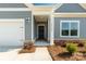 Close-up of home's front door with stone accents, white columns, and a well-manicured landscape at 10180 Lakeshore Dr, Lancaster, SC 29720