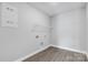 Bright laundry room offers gray walls, utility connections, and a single wire shelf for easy storage at 10180 Lakeshore Dr, Lancaster, SC 29720